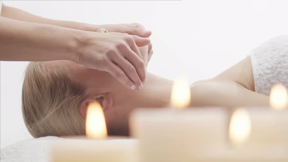 Young, healthy and beautiful woman gets massage therapy in the spa salon.