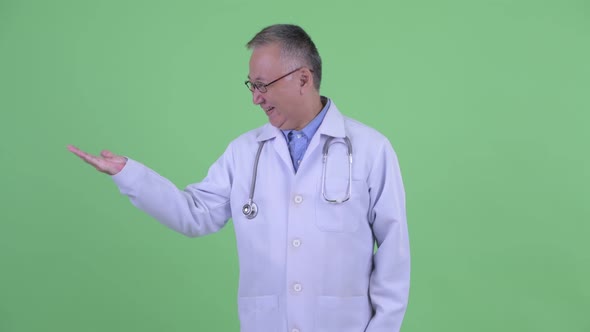 Excited Mature Japanese Man Doctor Comparing Something