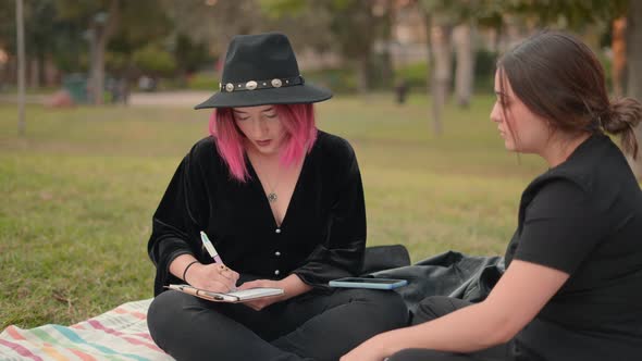 Women Sitting on Grass at Informal Job Interview Outdoors