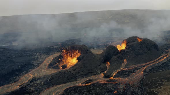 Drone shot of magma fountains in middle of smoky highlands of Iceland - aerial