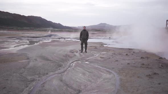Man standing in geothermal valley in mountains