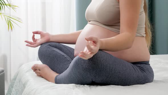 Panning Shot Young Pregnant Woman Meditating and Relaxing on Big Bed Next To Window at Home