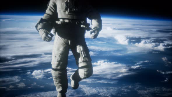 Astronaut in Outer Space Against the Backdrop of the Planet Earth alt