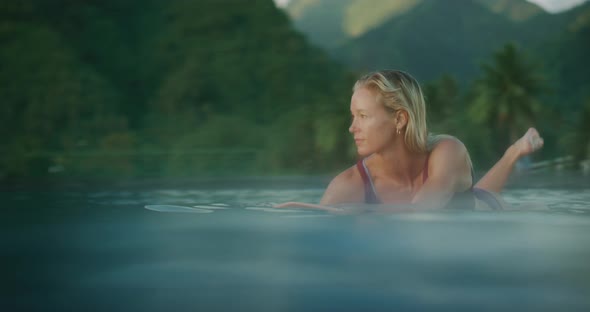 Woman surfing at sunset