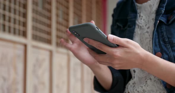 Close up of woman use of mobile phone in Chinese garden