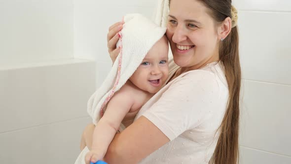 Smiling Mother Wiping Her Baby Son with Towel After Washing in Bath