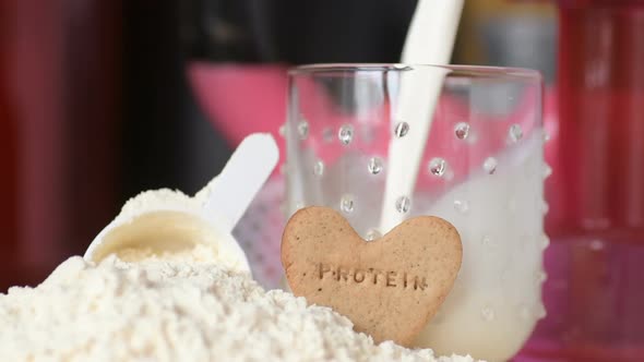 Protein powder and measuring scoop over the jar