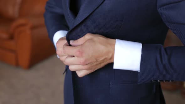 A Successful Young Man Puts on a Suit Jacket in the Morning.