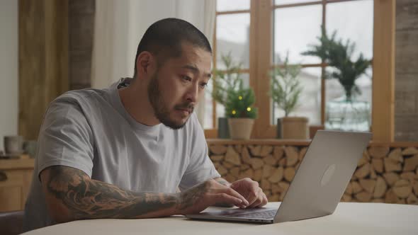 A Bunch of Various Facial Expressions By a Tattoed Asian Man in Front of His Laptop