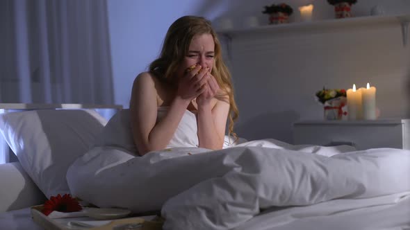 Woman Eating Doughnut and Crying in Bed, Struggling Stress With Excessive Food