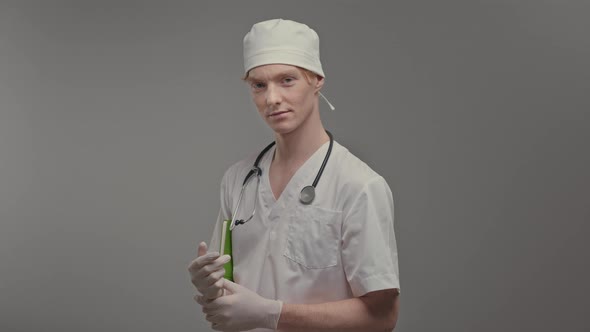 Young Doctor In Medical Gown And Gloves He Holds Tablet