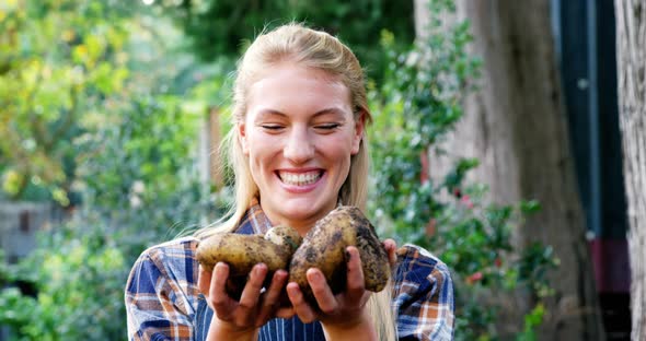 Happy gardener holding freshly cultivated potatoes