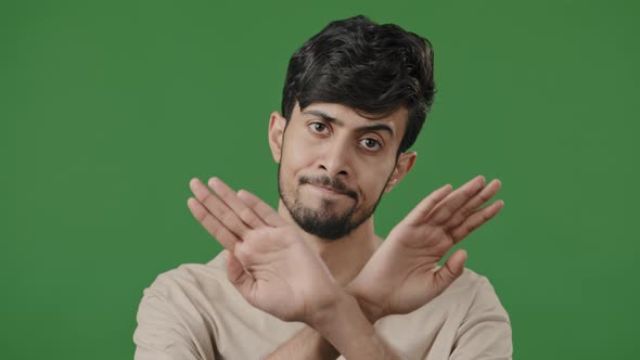 Arabic Man Hispanic Guy Standing Posing on Green Studio Background Shows Stop Gesture Prohibition