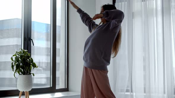 Young Woman in Wireless Headphones Dancing in the Room