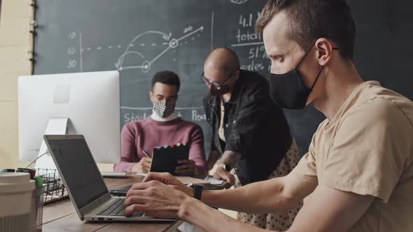 Man in Mask Using Laptop