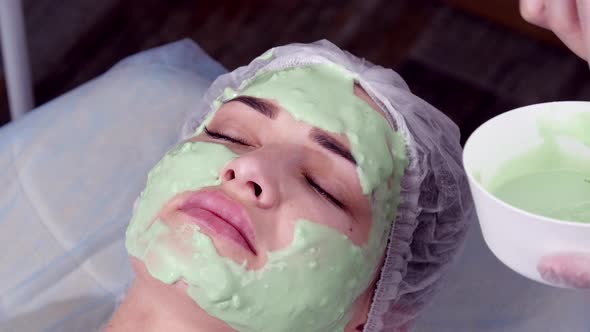 Beauty and Cosmetology Concept. Young Woman with Cream Mask in a Beauty Parlour