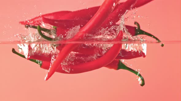 Super Slow Motion Chilli Pepper Falls Into the Water with Splashes