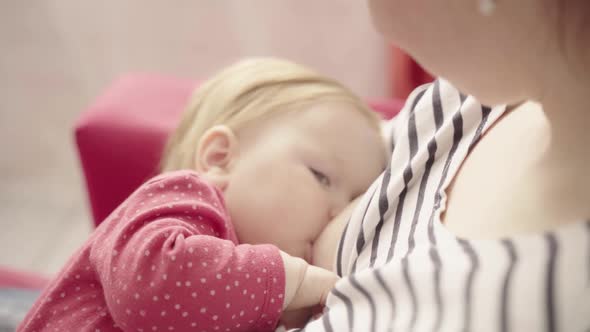 Young Mother Breastfeeding Baby Girl