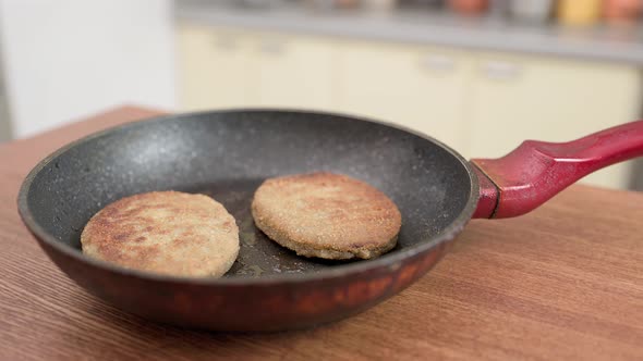 Fish cutlets in a frying pan with oil. The camera Moves Around the Table in the kitchen.