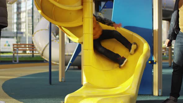 5-Year-Old Caucasian Boy Going down Spiral Slide on Playground