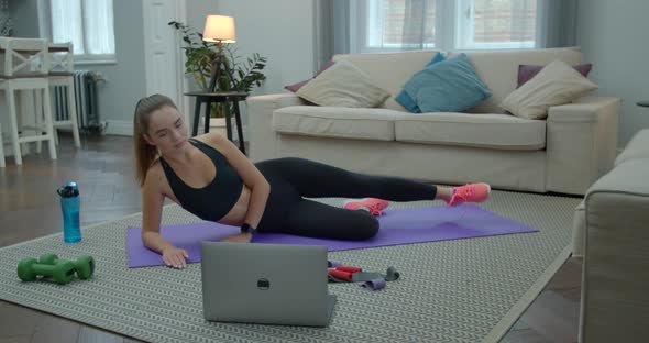 Fitness Young Woman Doing Exercises in Black Sportswear in Home Apartment with Help of Her