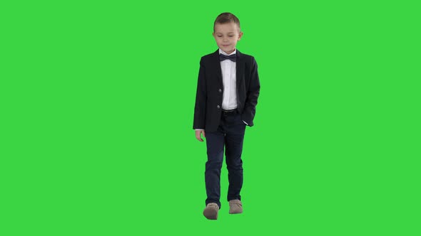 Boy in Formal Costume Walking with a Hand in Pocket on a Green Screen, Chroma Key.