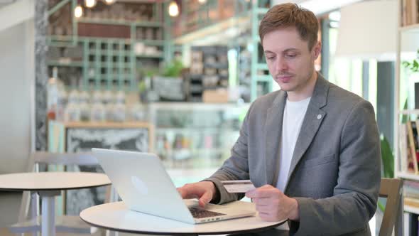 Successful Online Payment on Laptop By Young Man