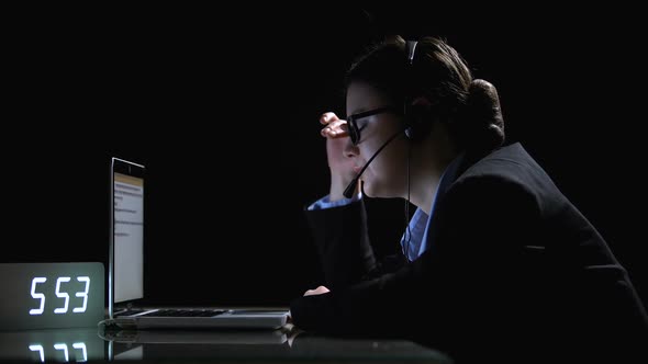 Tired Female Taking Off Headset and Glasses