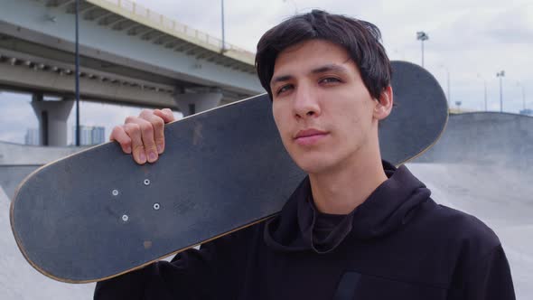 Handsome Guy Keep Skateboard on Shoulder at Street