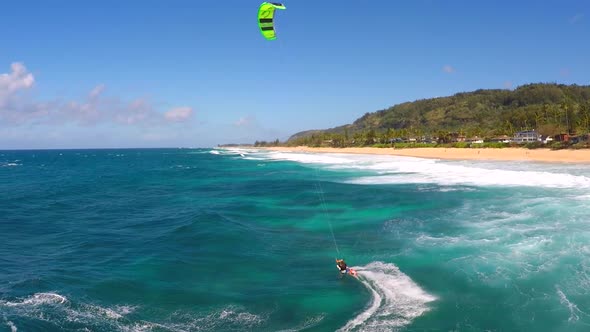 Aerial view of a man kitesurfing in Hawaii.