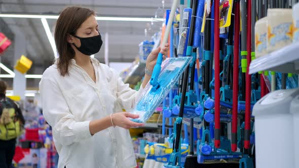 Woman Buyer in Mask Choosing a Floor Mop