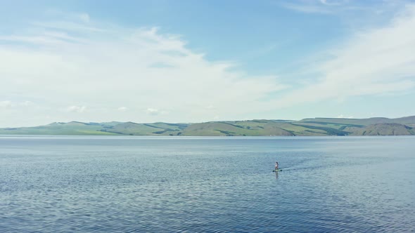 Aerial View of a Woman Surfing on a Mountain Lake