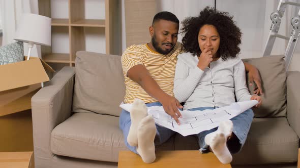 Couple with Boxes and Blueprint Moving To New Home