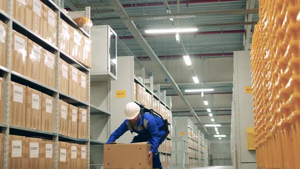 Male Worker is Relocating a Package While Wearing Ergoskeleton