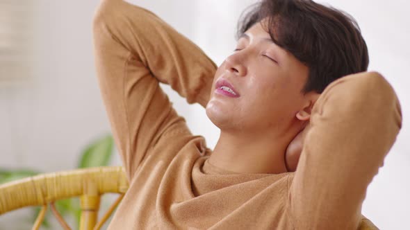 Happiness Asian handsome man lying on sofa close her eyes sleep deep breath relaxation at home