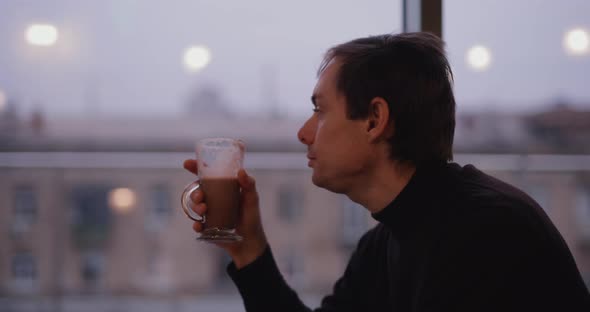 Man Drinking Cocoa in a Cafe