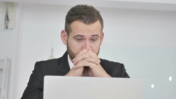 Tired Businessman Rubbing Eyes While Working on Laptop