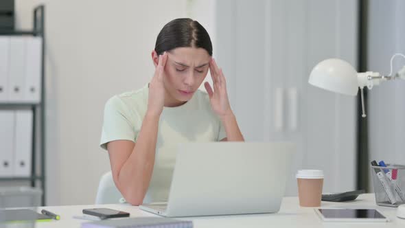 Young Latin Woman with Laptop Having Headache 