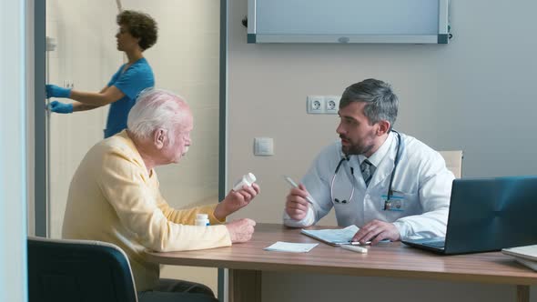 Elderly man discussing pills with doctor