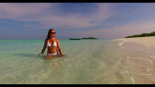 Lady alone enjoys life on tropical shore beach vacation by blue sea with white sandy background of t