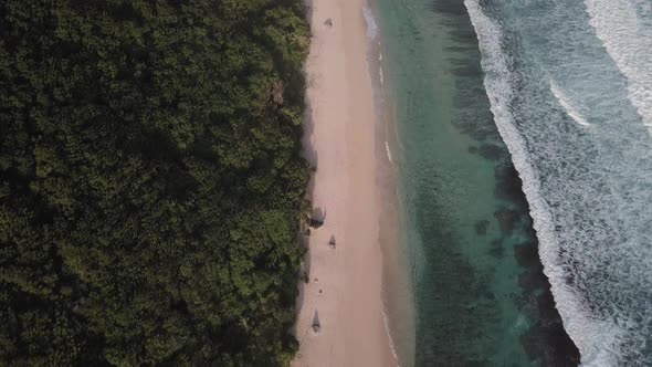 Aerial View of Tropical Beach with Azure Blue Water and Foaming Ocean Waves