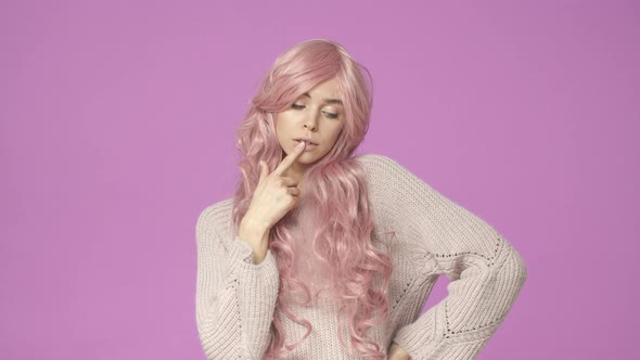 Silly and Timid Tender Adorable European Woman in Pink Wig Seater Touching Lip and Looking Down