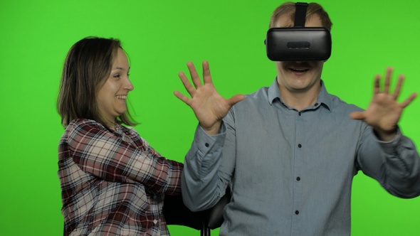 Man and Woman Using VR Headset Helmet To Play Game. Watching Virtual Reality 3D Video. Chroma Key