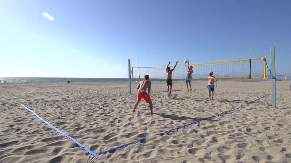 Men playing beach volleyball.