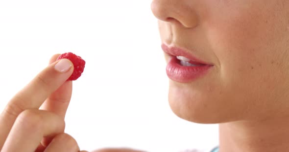 Close-up of woman having raspberries