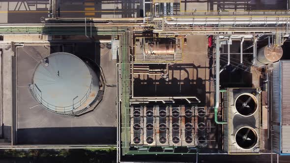 Aerial Top Down View Over Chemical Factory with Many Storage Tanks Fans and Pipelines