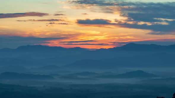 Timelapse sunrise with fog above mountain peak