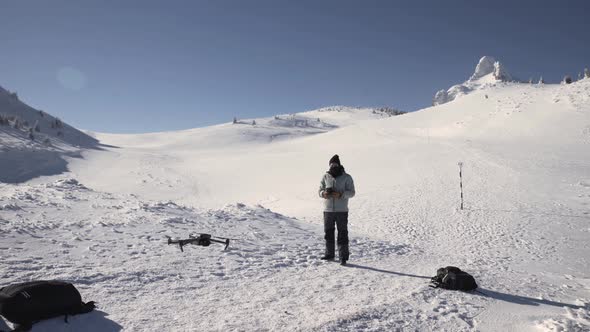 Pilot Landing His Drone On Frozen Ground During Winter