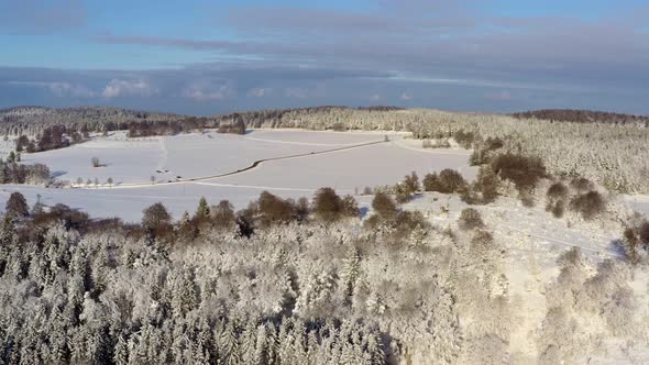 Aerial timelapse of a winter landscapes with driving cars at the snowy background