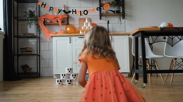 Little Girl Playing Pumpkin Bowling in Halloween